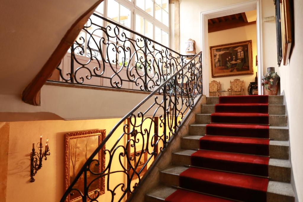 a staircase in a home with a wrought iron railing at Hôtel de la Cathédrale Metz in Metz