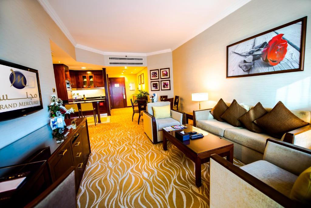 a living room with a couch and a table at Grand Mercure Majlis Residences in Abu Dhabi