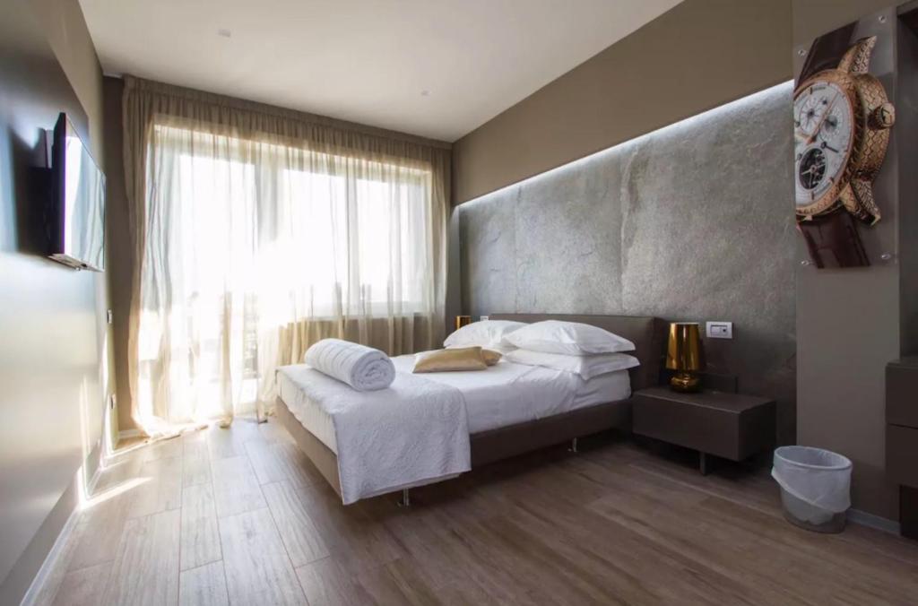 a bedroom with a bed and a large window at Ginevra Rooms in Bergamo