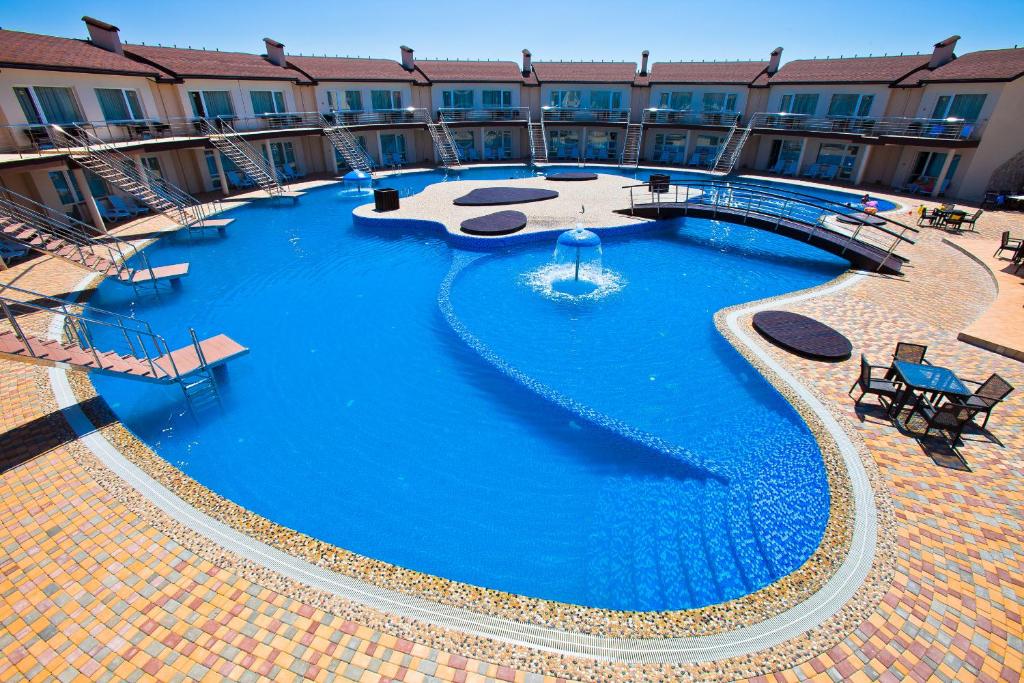 a large blue swimming pool in a building at Elizium Park Hotel in Koblevo