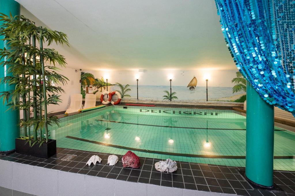a swimming pool in a hotel with an ocean view at Pension Deichgraf Middelhagen in Middelhagen