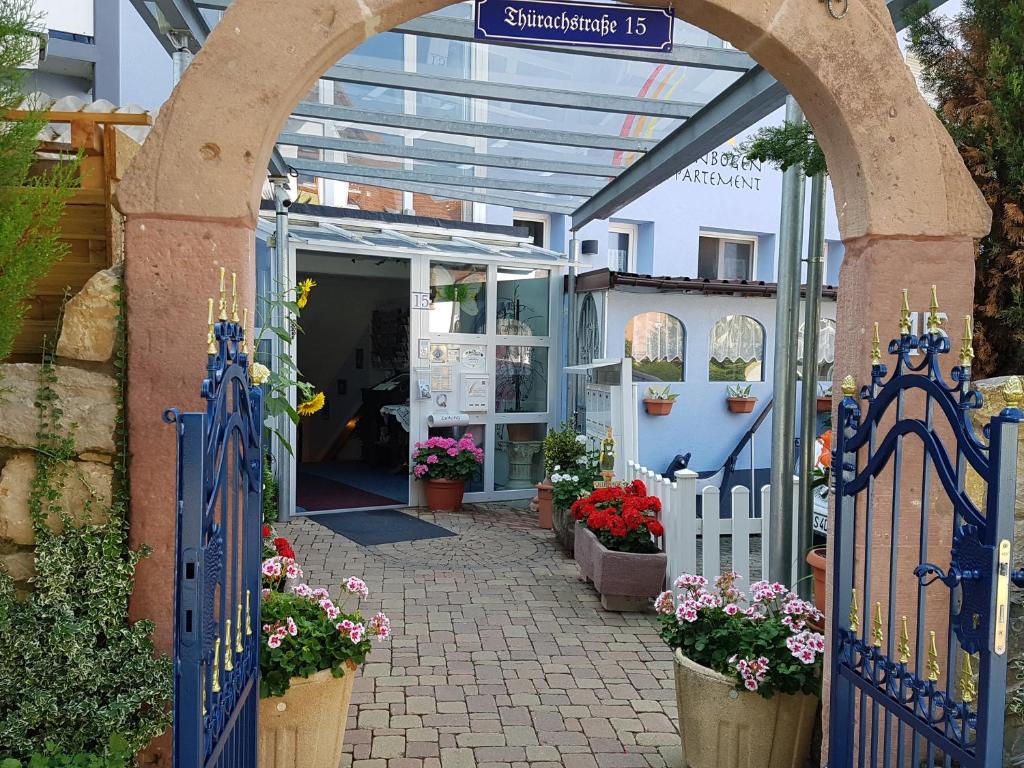 an entrance to a flower shop with a blue gate and flowers at Regenbogen-Appartement in Bad Krozingen