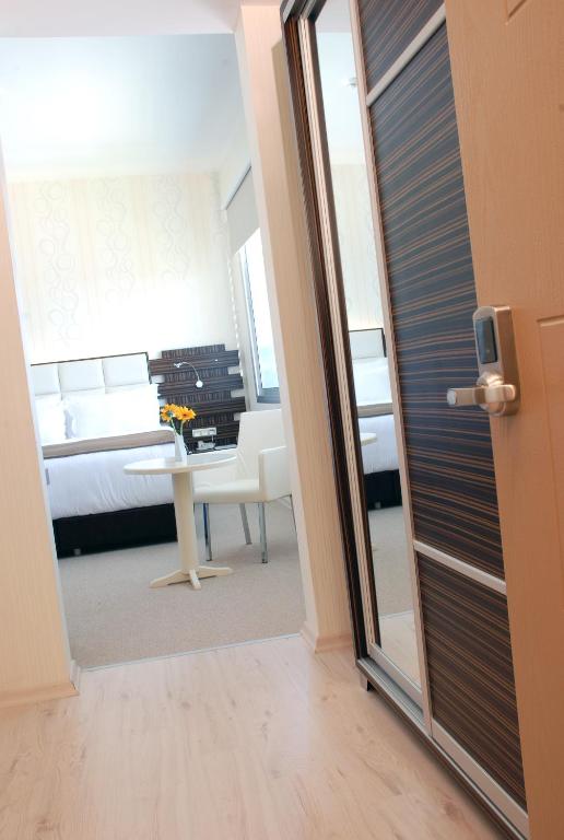 a room with a bed and a room with a mirror at Orty Airport Hotel in Izmir