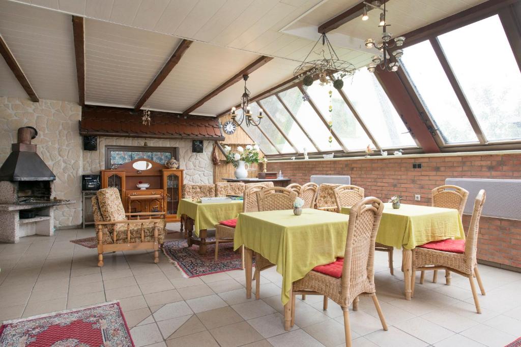 ein Esszimmer mit Tischen, Stühlen und einem Kamin in der Unterkunft Pension Deichgraf Middelhagen in Middelhagen