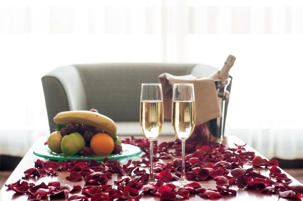 a table with two wine glasses and a plate of fruit at ISG Sabiha Gökçen Airport Hotel in Istanbul