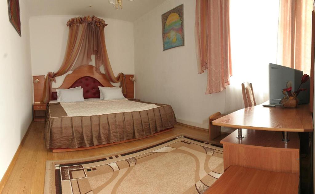 una camera con letto, tavolo e scrivania di Volter Hotel a Lviv