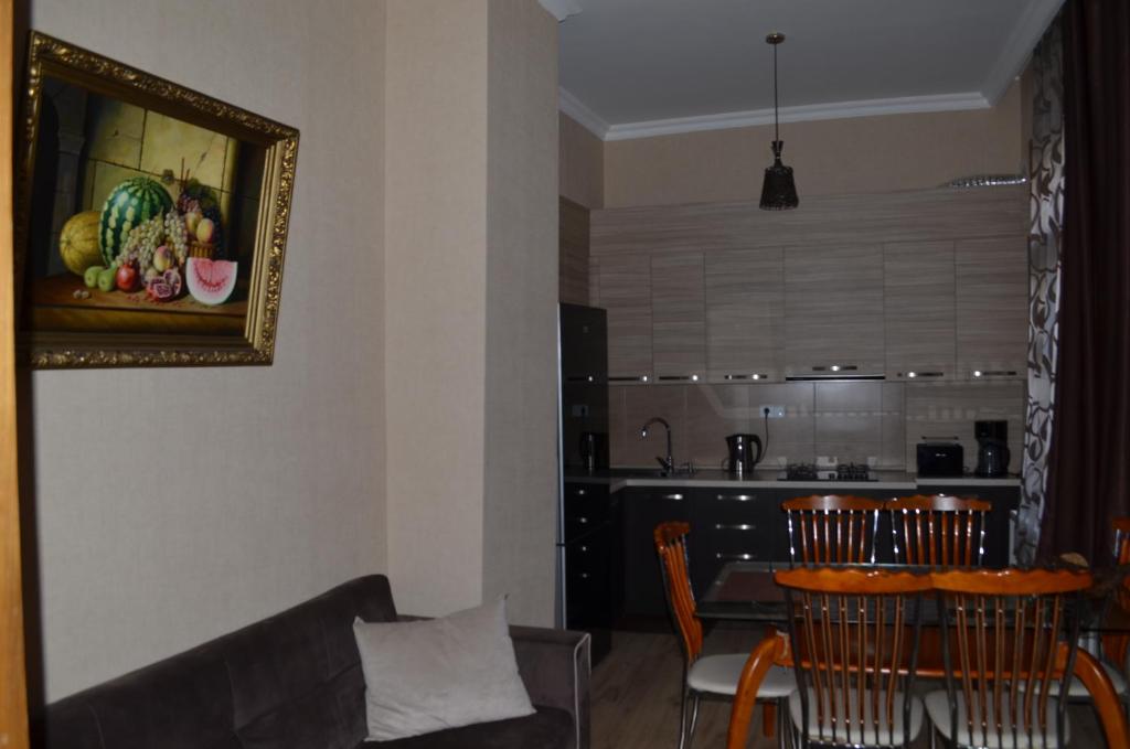 sala de estar con sofá y mesa con sillas en Happy Home Sololaki, en Tiflis