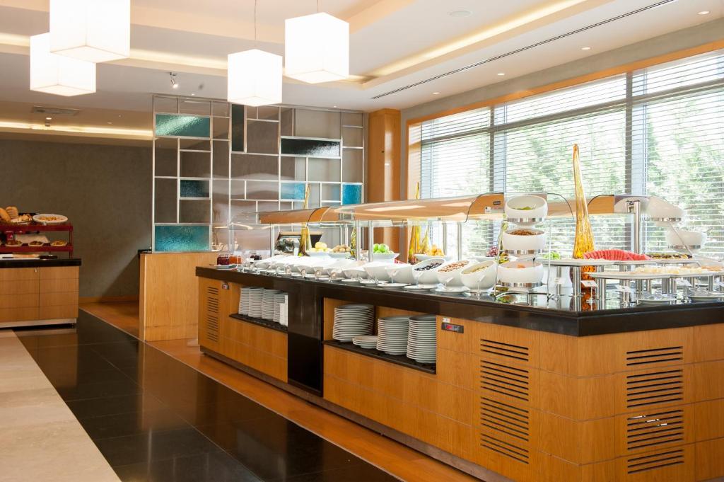 a restaurant with a counter with dishes on it at ISG Sabiha Gökçen Airport Hotel in Istanbul