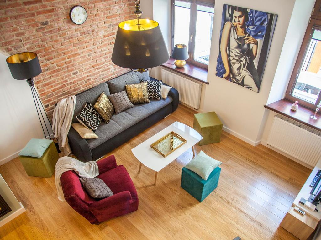 salon z kanapą i ceglaną ścianą w obiekcie BC7 Apartments w Krakowie