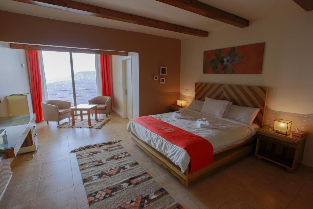 a bedroom with a bed with a red blanket and a desk at Dana Guesthouse in Dana