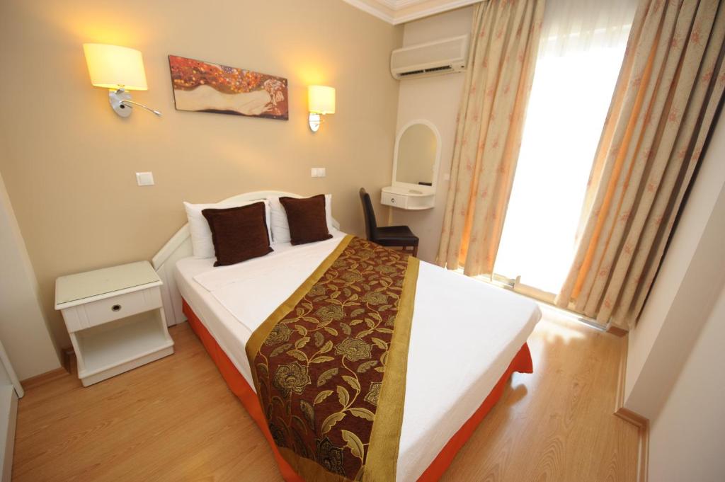 a bedroom with a bed and a large window at Suite Laguna Otel in Antalya