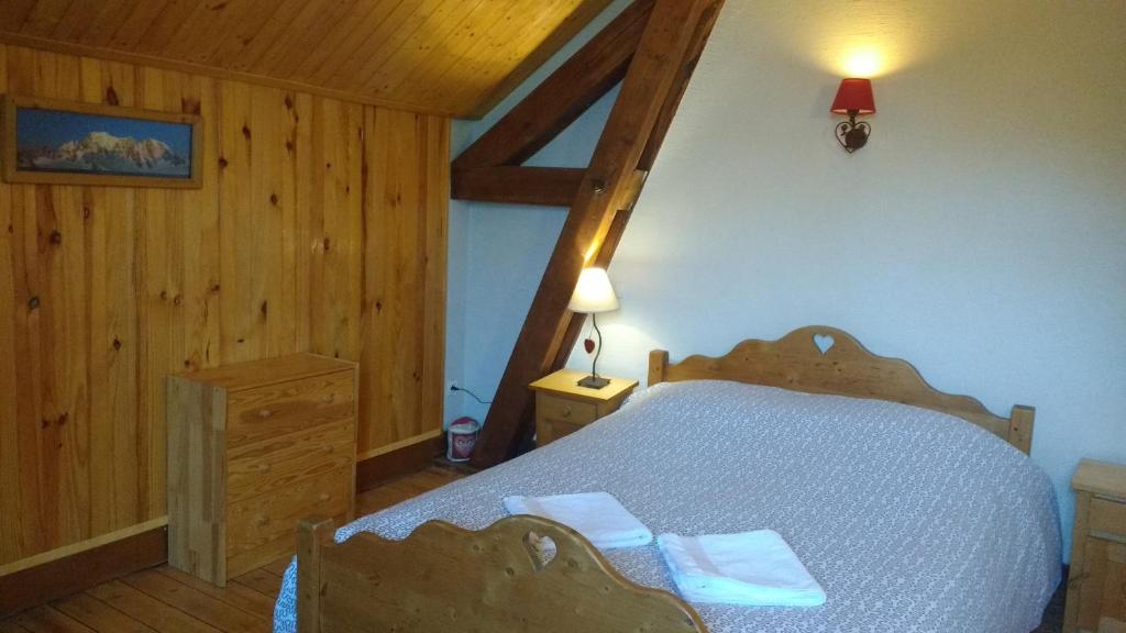 ein Schlafzimmer mit einem Bett in einem Zimmer mit Holzwänden in der Unterkunft Gîte Mont Joly in Saint-Gervais-les-Bains