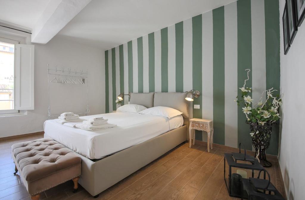 フィレンツェにあるApartments Florence - San Marco Suite 3の緑と白のストライプの壁、ベッド付きのベッドルーム1室