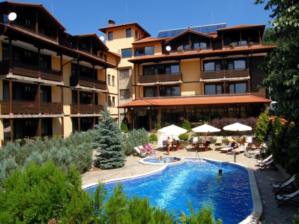 a hotel with a swimming pool in front of a building at Hotel Center in Apriltsi