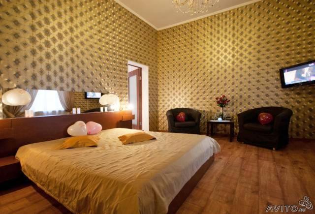 a bedroom with a large bed and two chairs at Guest House Geralda on Marata 14 in Saint Petersburg