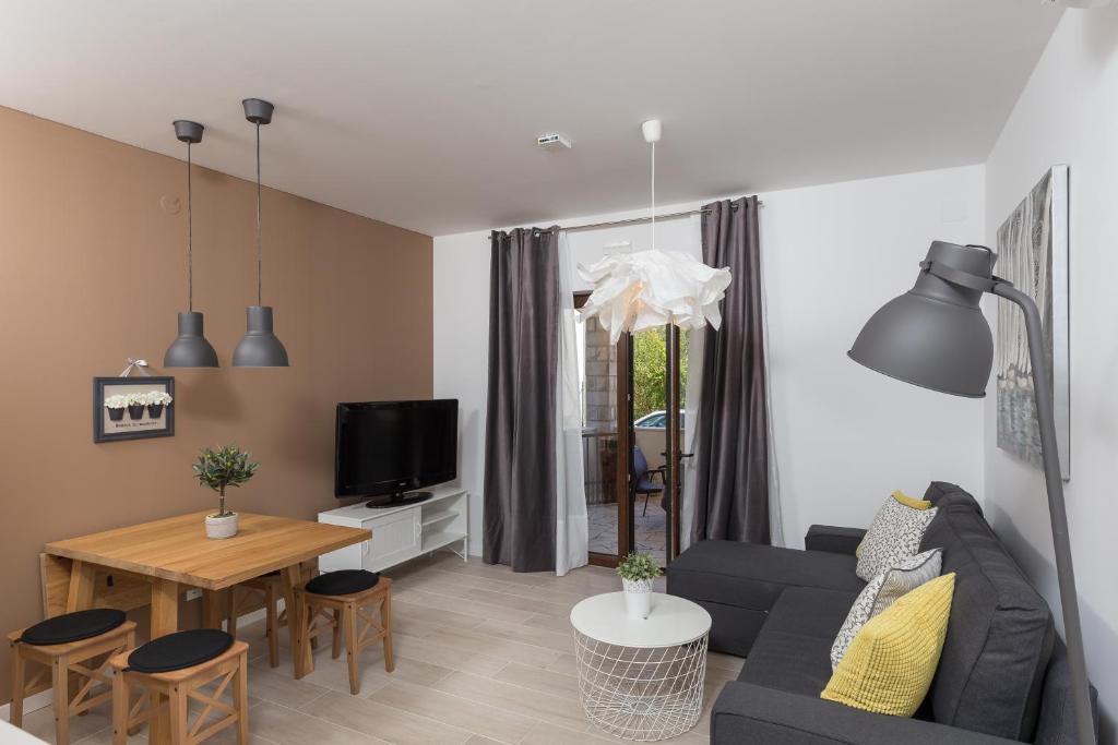uma sala de estar com um sofá e uma mesa em Apartments Venka em Mokosica