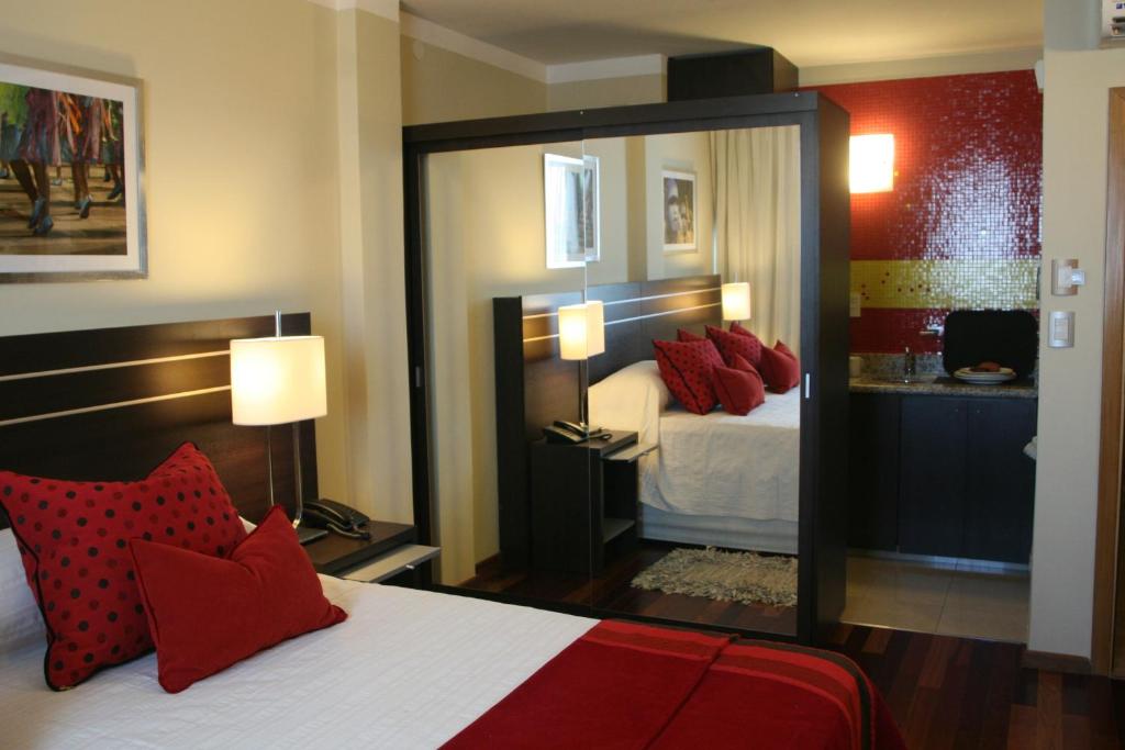 Habitación de hotel con cama con almohadas rojas en Zoom Apartments Hotel Boutique en Córdoba