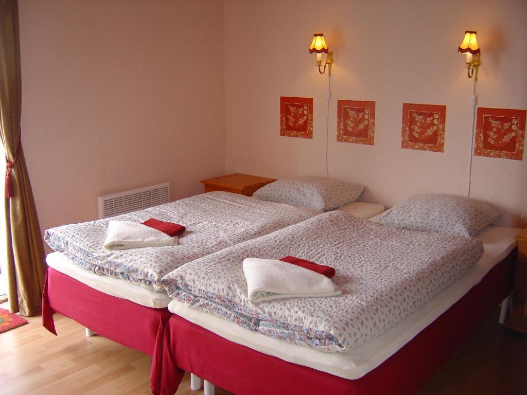two beds in a bedroom with red pillows on them at Bed and Breakfast Vester Hjermitslev in Saltum