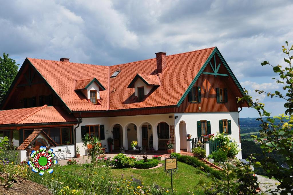 ein großes Haus mit rotem Dach in der Unterkunft Gmiatliche Stubm in Loipersdorf bei Fürstenfeld