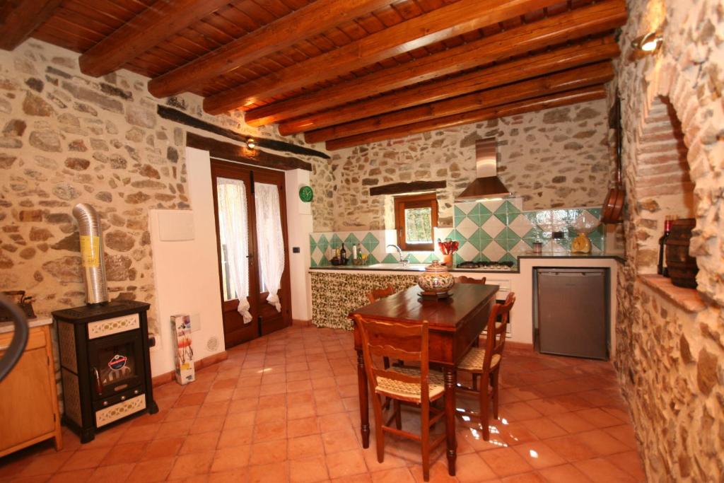 a kitchen with a wooden table and a stove at La corte di Pietro in Isnello