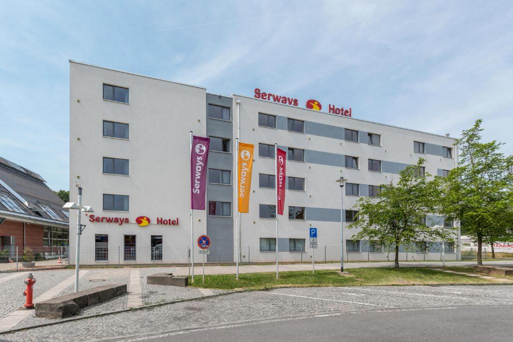 a white building with signs on the side of it at Serways Hotel Spessart in Rohrbrunn