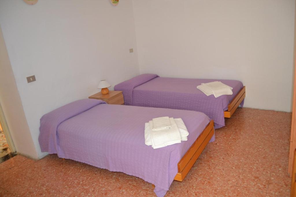 2 letti in camera d'albergo con lenzuola viola di Casa Vacanze Da Nonna Maria a Guardiagrele