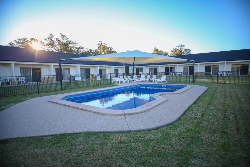 a swimming pool in a yard next to a building at Roma Explorers Inn in Roma