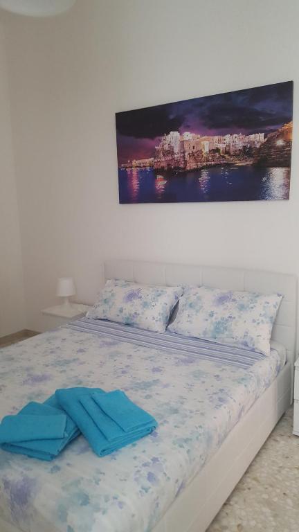 ein Bett mit blauen Handtüchern darüber in der Unterkunft BETTY & ROSY- Locazione Turistica in Polignano a Mare