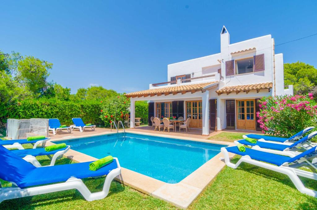 a villa with a swimming pool in front of a house at Ca Na Martina in Cala d´Or