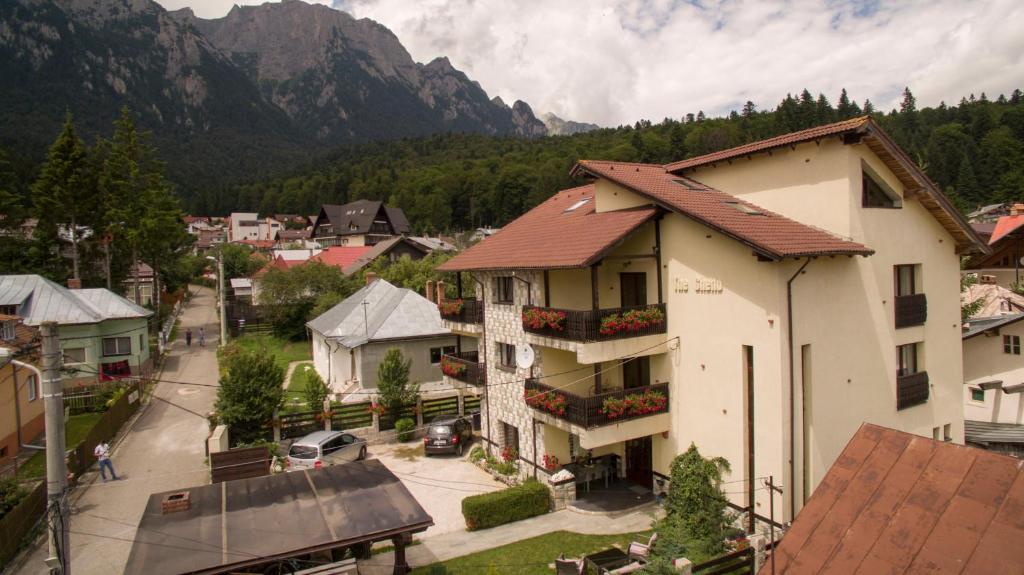 a building in a town with mountains in the background at The Ghetto in Buşteni