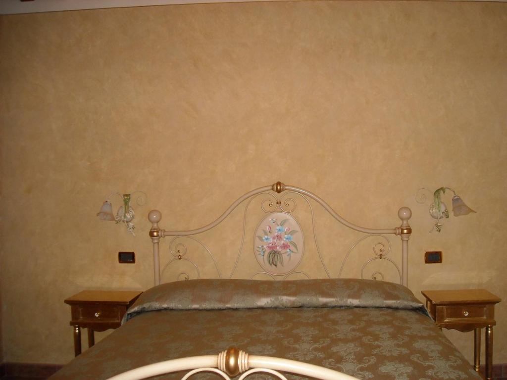 1 cama en un dormitorio con 2 mesitas de noche y 2 mesas en Appartamenti Roberta Cisanello, en Pisa