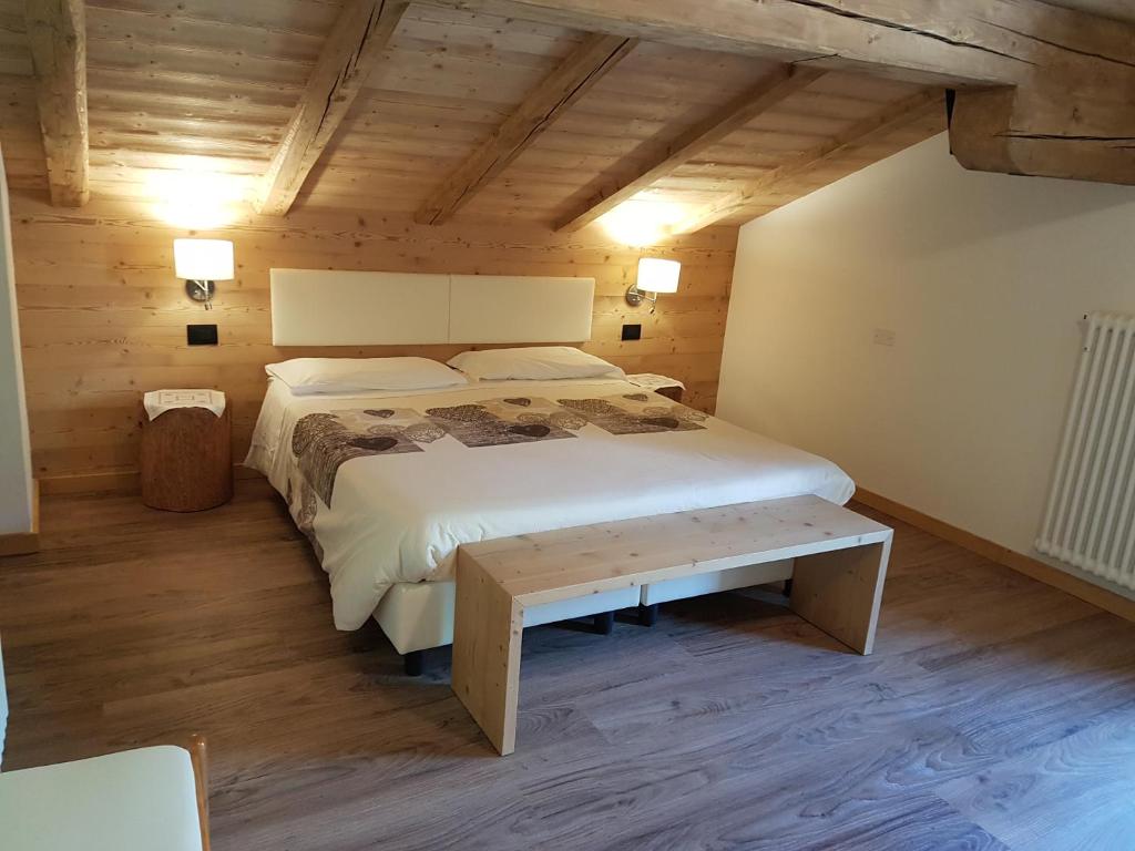 ein Schlafzimmer mit einem großen Bett und einem Tisch in der Unterkunft B&B Bucaneve in Vigo di Fassa