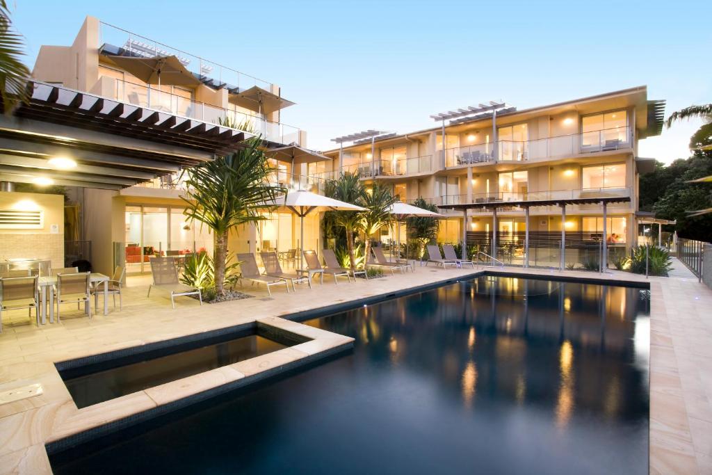 a large swimming pool in front of a large building at Maison Noosa in Noosa Heads
