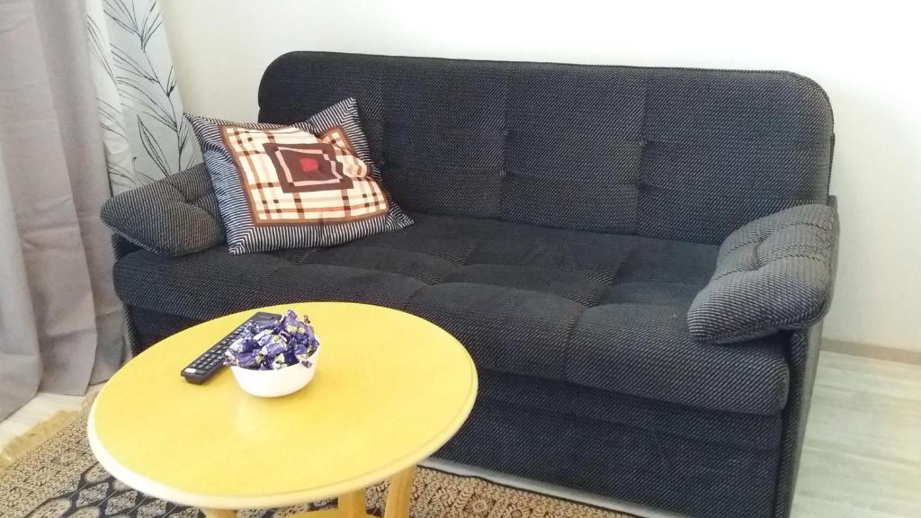 a living room with a black couch and a table at New nice apartment in Vaasa