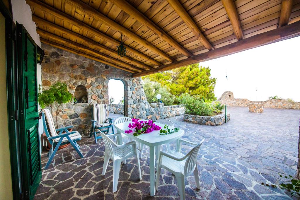a patio with a table and chairs and a stone wall at Portynord in Canneto