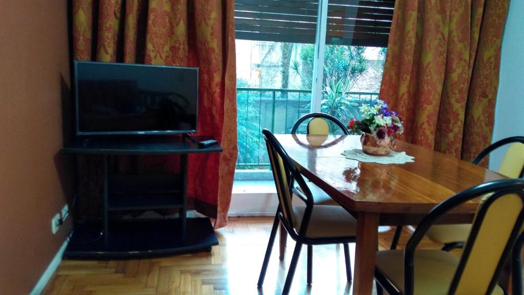 mesa de comedor con TV y mesa con sillas en Apartamento Luz en Buenos Aires