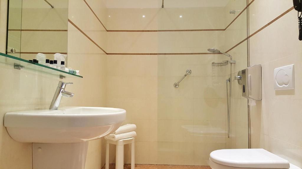 a bathroom with a sink, toilet, and bathtub at Hotel Roma e Rocca Cavour in Turin