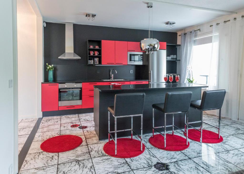a kitchen with red cabinets and red stools at Asunto 28 in Saarijärvi