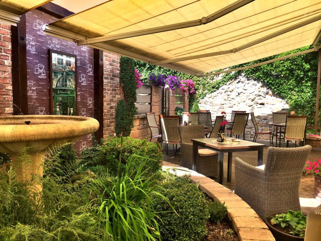 un patio con fontana, tavoli e sedie di Penzion Bily Beranek a Kadaň