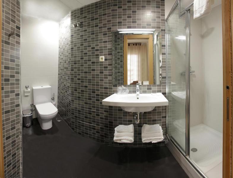 y baño con lavabo, ducha y aseo. en Hostal Falfes, en Madrid
