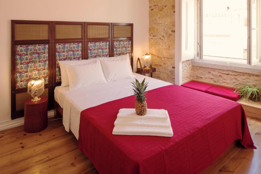 a bedroom with a large bed with a red blanket at Lisbon Calling Rooms & Studio in Lisbon