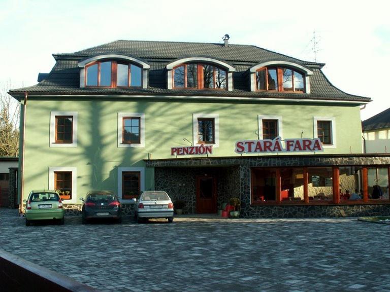 a large building with cars parked in front of it at Penzion Stara Fara in Makov