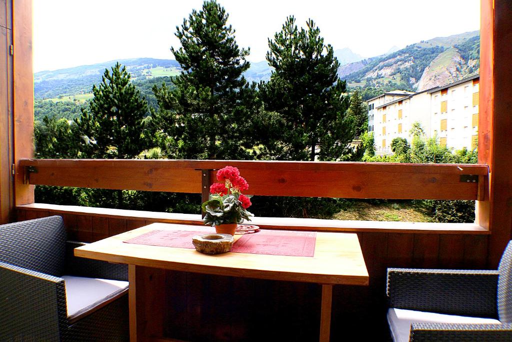 a table with a vase of flowers on top of a window at Studio Résidence Glières in Bourg-Saint-Maurice