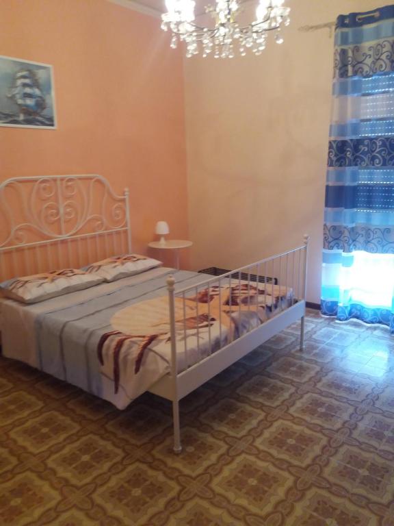 a bedroom with a bed and a chandelier at Stella Marina in Giardini Naxos