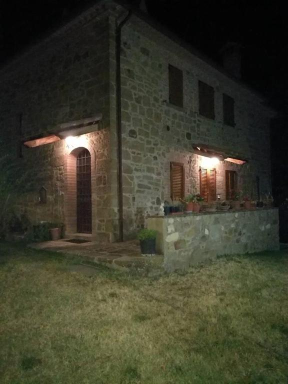 a stone building with two windows at night at Villa Il Corniolo in Morra