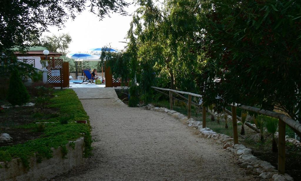 a walking path in a yard with a fence at Althea Village Residence in Vieste