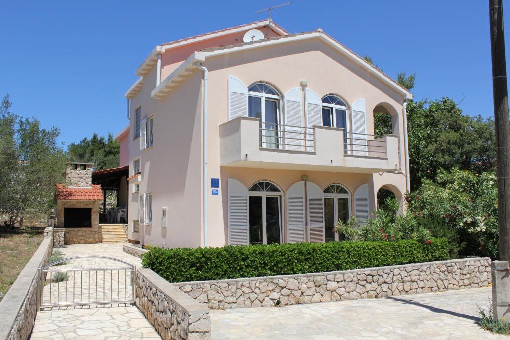 Cette grande maison blanche est dotée d'un mur en pierre. dans l'établissement Apartments Matlovac, à Ždrelac