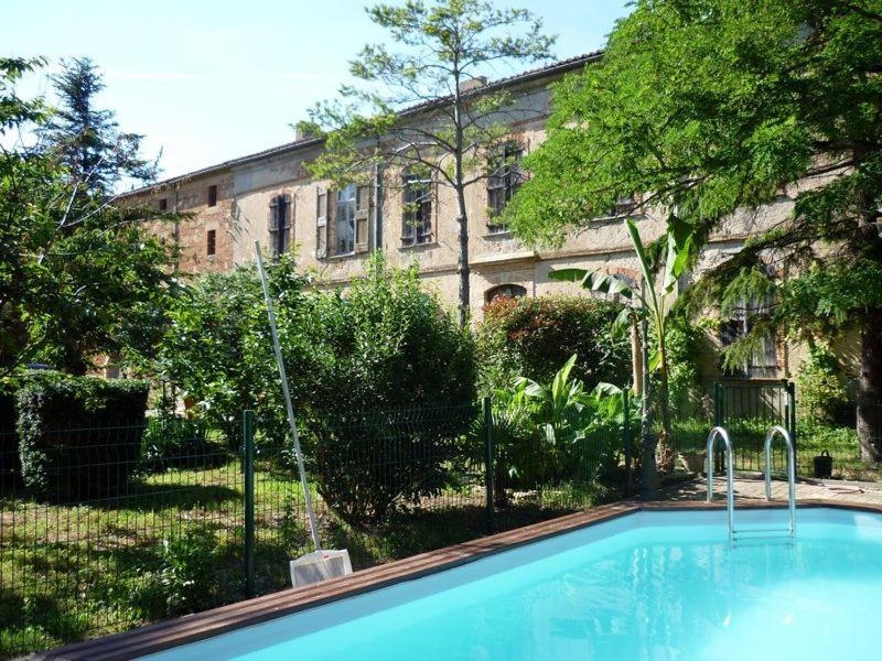 a swimming pool in front of a building at Château de Vallègue in Vallègue