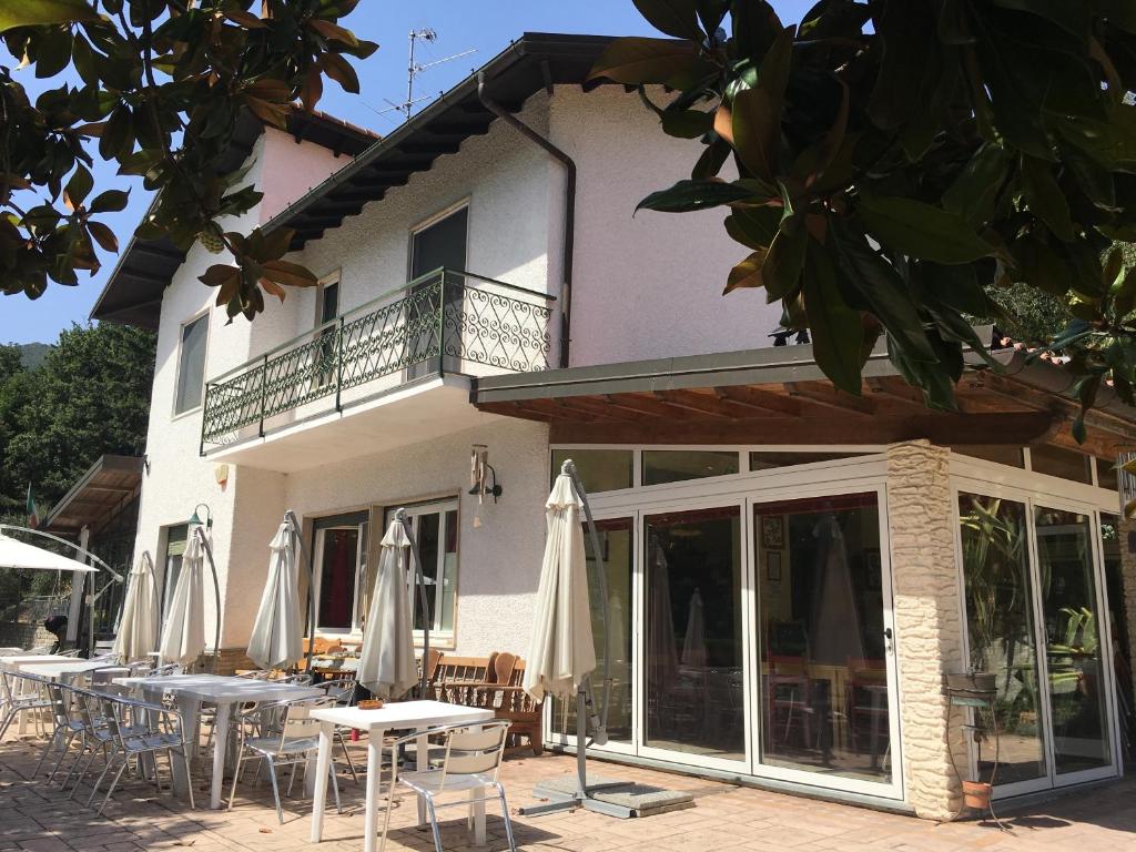 a building with tables and umbrellas in front of it at Agriturismo Valdolivo in Cogoleto