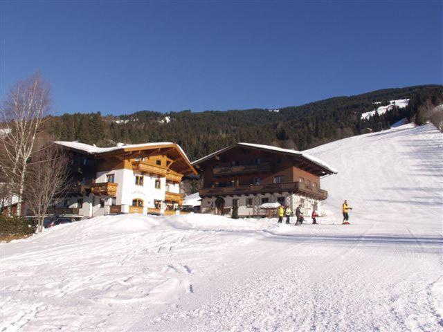 a group of people standing in the snow in front of a ski lodge at Ferienhaus Grubhof in Saalbach Hinterglemm